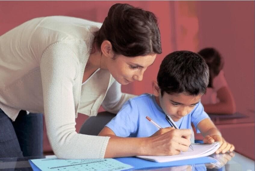 Tutor and boy doing blue sheets in class